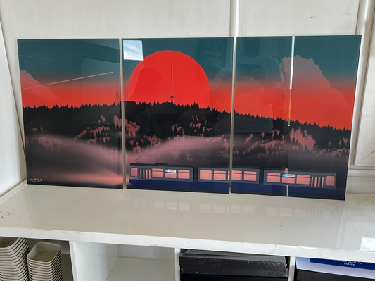 A three-panel wall art print depicting a red sunset behind the Uetliberg along the bottom, has tram 14 Triemli.